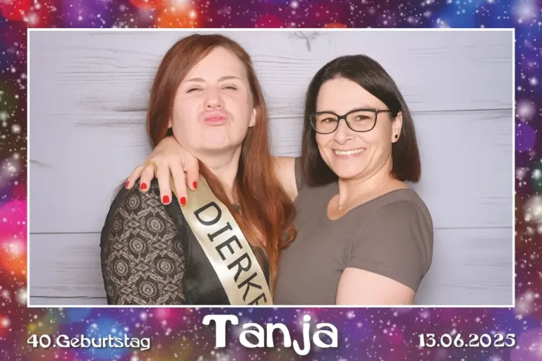 fotobox-meiningen-geburtstag Zwei Frauen vor der Fotobox in Meiningen bei einem 40. Geburtstag – Rahmen mit bunten Lichteffekten und dem Namen ‚Tanja